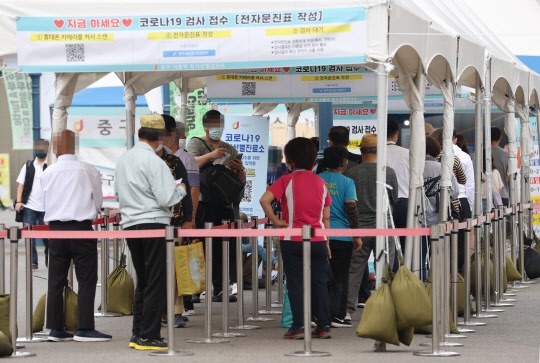 5일 오전 서울역광장에 마련된 코로나19 임시 선별검사소에서 시민들이 검사를 받기 기다리고 있다.  연합뉴스